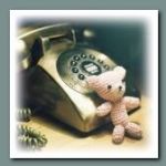 Маленький игрушечный мишка у телефона