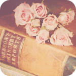 Нежные розы лежат на толстой старой книге