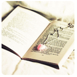Розовый кулон лежит на книге
