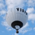 Белый воздушный шар летает среди облаков